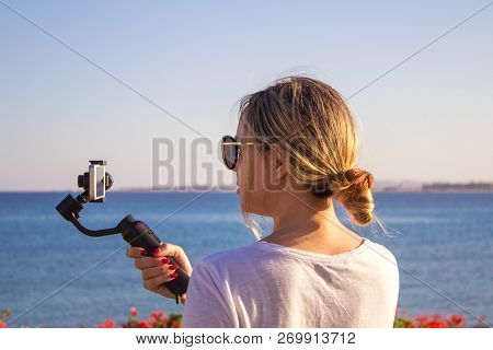 Attractive Female Records Video With Modern 3d Gimbal Stabilized Camera Smartphone