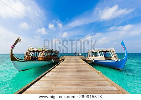 Maldives Traditional Boat Dhoni Dock Next To Wooden Jetty On Tropical Blue Sea. Maldives Idyllic Lan