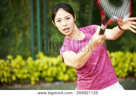 Young Asian Woman Female Tennis Player Hitting Ball With Forehand