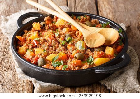 Beef Picadillo Cooked With Potatoes, Carrots, Raisins, Olives And Spices Close-up In A Frying Pan. H