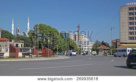 Shkoder, Albania - July 25, 2012: Ebu Bekr Mosque Towers Church Bell Tower And Fountain At Democracy