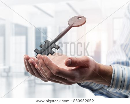 Cropped Image Of Businessman In Suit Keeping Stone Key Symbol In Hands. Mixed Media