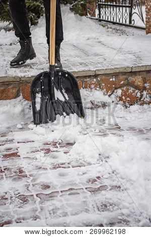 After A Snowfall, A Man Clears Snow From The Road In Winter, Work In The Winter Season.