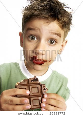 Close Up of Young Boy Eating A chocolate bar.