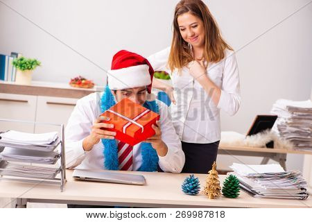 Colleagues exchaing christmas presents in office