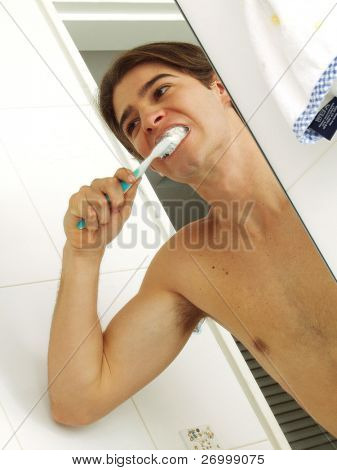 uomo di spazzolare i denti in un bagno.