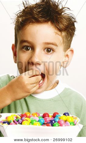 Petit garçon, manger des bonbons sur fond blanc. Petit garçon mangeant chicle.