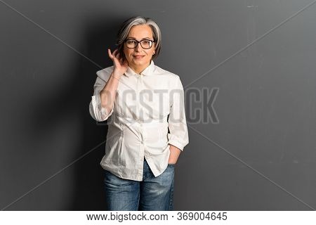 Pretty Mature Woman Corrects Medium-length Hairstyle Coquettishly. Adorable Gray-haired Caucasian Mo