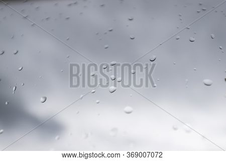 Water Drops On Glass Window With Dark Clouds On Background
