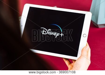 Girl Holding A Tablet With Disney Plus Logo On The Screen. High Quality Photo.