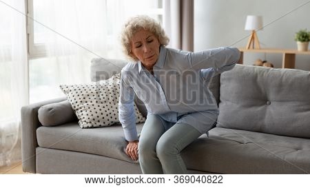 Old Woman Gets Up Off The Sofa Feels Repeated Low Backpain