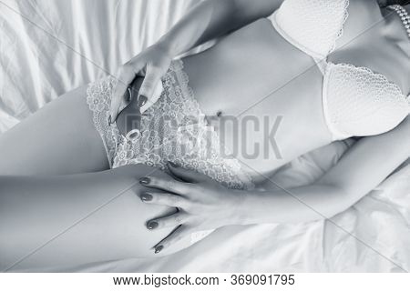 Sexy Woman In White Lingerie Holds Clitoris Sex Toy And Lying On The Bed.