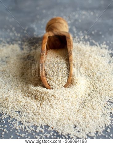 Raw Uncooked Fonio Seeds With A Spoon On Grey Background Close Up