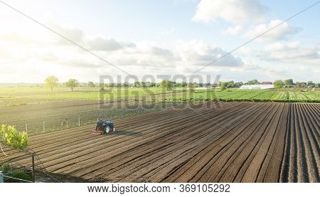 A Tractor Rides On A Farm Field. Farmer On A Tractor With Milling Machine Loosens, Grinds And Mixes 