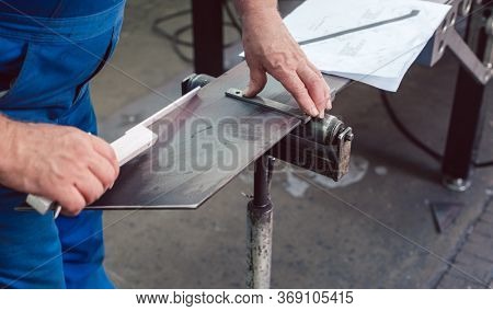 Metalworker measuring a strip of steel for his next project