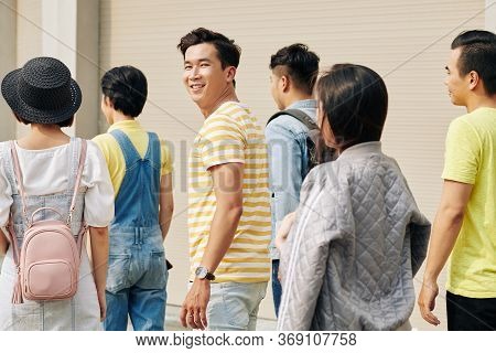 Smiling Vietnamese College Student Turning Back And Smiling At Camera When Walking Outdoors With Fel