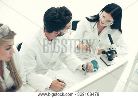 Top View.a Group Of Scientists Working On A Computer In The Labo