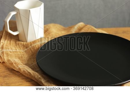 Empty Black Plate And White Cup. Empty Dishes. Minimalistic Set Of Dishes. Plate Without Food