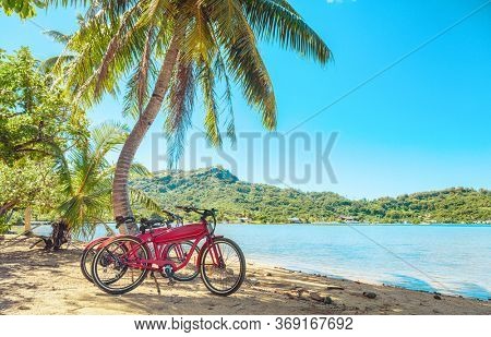 Cycling tourism e-bike bikes biking tour excursion tourists summer vacation travel landscape. Tahiti island bicycles on beach.