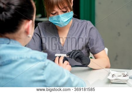 Famele Manicurist Is Doing Manicure With Protective Mask.