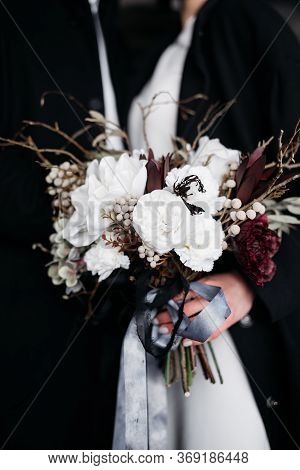 Close-up Of A White Bouquet With Silk Ribbons, On A Black Background, In The Hands Of The Bride. Des