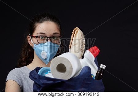 Young Woman In A Valve Of The Respiratory Protective Mask With A Bag Full Of Groceries From The Supe