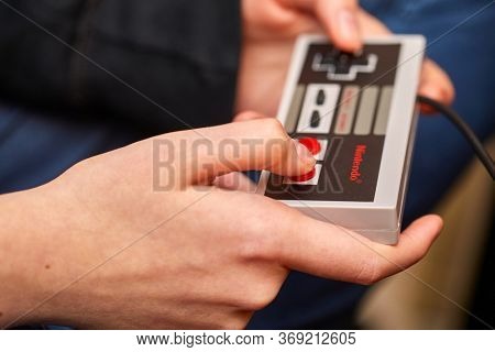 BUDAPEST, HUNGARY - FEBRUARY 17, 2018: Playing the classic Nintendo NES console from the 80s, controller closeup