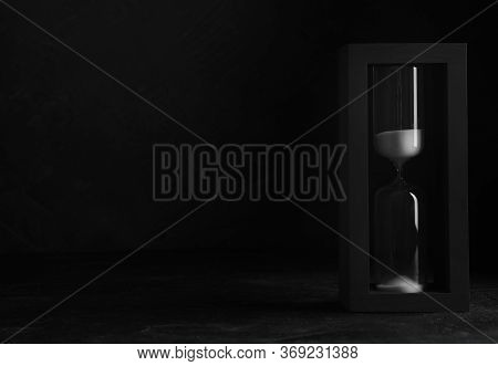 Sandglass On Table Against Black Background, Space For Text. Pareto Principle Concept