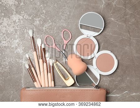 Cosmetic Bag With Makeup Products And Beauty Accessories On Marble Background, Flat Lay