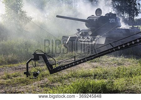 Filming A Tank Shrouded In Smoke. Soviet Tank T-34 On The Move. Cameras Filming The Tank. A War Scen