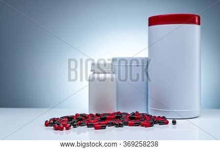 Antibiotic Capsule Pills Spread On White Table And Plastic Drug Bottle White Blank Label. Antibiotic