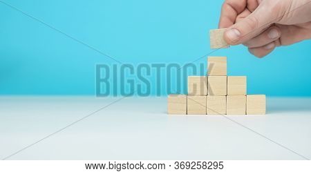 Hand Arranging Wood Block Stacking As Step Stair On Wooden Table. Business Concept For Growth Succes