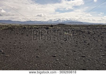 Black Lava Desert In Iceland, Europe With The Hekla Volcano In The Background