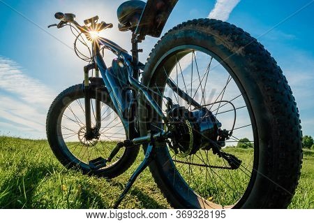 Electric Bicycle With Thick Wheels In Nature. Fatbike Close-up.