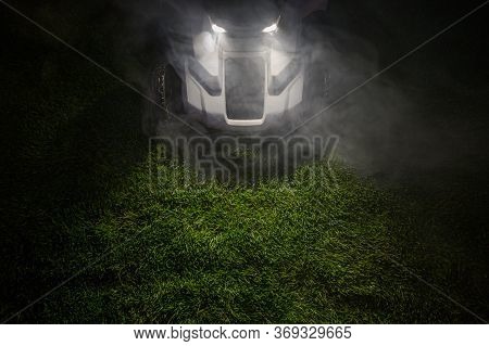 Late Evening Hours Grass Field Mowing Using Modern Wireless Electric Mower