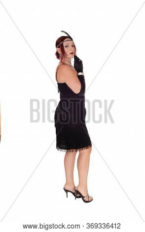 A Beautiful Woman Standing In A Black Dress In Profile With Her 
Red Hair And Head Band And Cloves, 