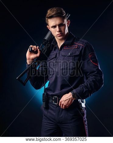 A Guy In A Police Uniform With A Short Barreled Automatic Rifle With A Telescopic Sight Takes Aim