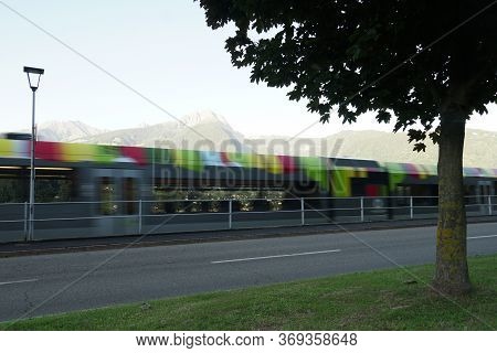 Colourful Photography, A Blurred Regional Train In Merano, South Tirol, Italy. Peak Ifinger On The R