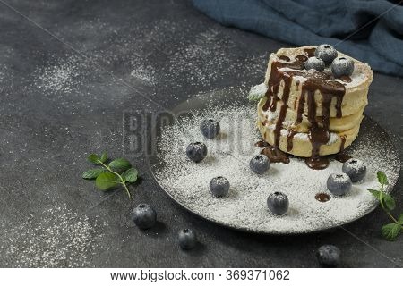 Japanese Soft Pancakes With Blueberries, Hot Chocolate And Sprinkle With Icing Sugar On A Round Dark