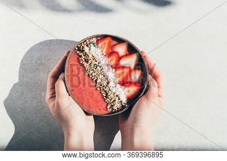 Pink Smoothie From Banana And Strawberries With Pieces Of Strawberries, Granola And Coconut Shreds O