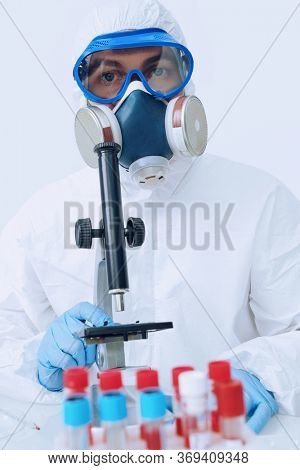 COVID-19. Doctor, microbiologist, scientist in a protective suit, makes a study of coronavirus in the laboratory. Coronavirus test.