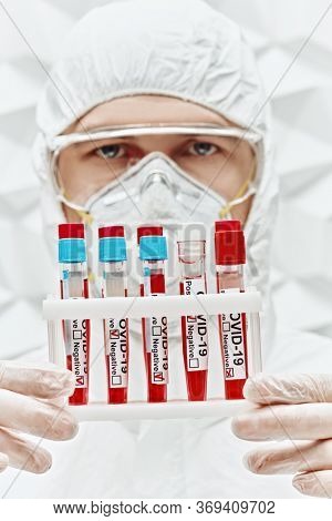 COVID-19. Doctor, microbiologist, scientist in a protective suit, makes a research on blood samples of infected people in the laboratory. Coronavirus test.