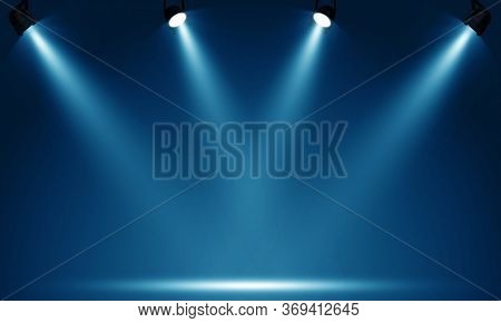 Spotlights illuminate empty stage blue background.