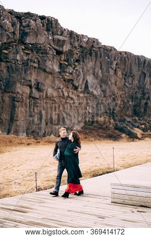 A Guy And A Girl Are Walking Down The Road In The Silfra Fault, In The Tingvedlir Valley.