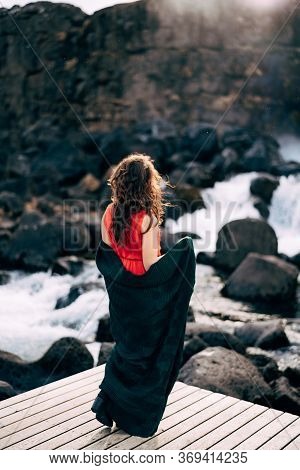 A Girl In A Red Dress Near Ehsaraurfoss Falls, Ehsarau River, National Park, Tingwedlir, Sudurland R