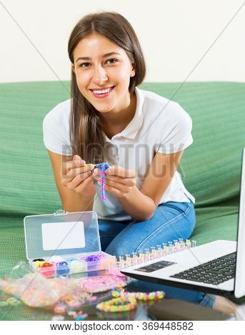 Happy Woman Makes Braslets With Elastic Rainbow Loom Bands