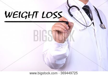 A Doctor In Medical Clothing Writes A Diagnosis, Text Weigth Loss With Hand Holding A Marker. Medica
