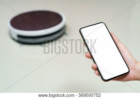 Hand Holding Smartphone With Blanking Screen For Control Robotic Vacuum Cleaner . Smart Life Technol