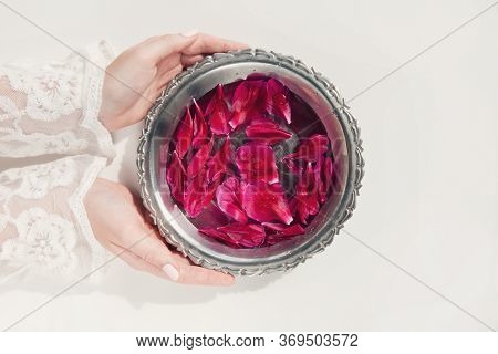 Dark Pink Peony Petals In Female Hands And In Bowl With Clear Water On White Background. Organic Cos