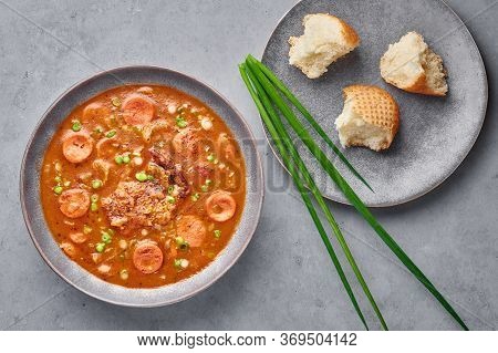 Chicken And Sausage Gumbo Soup In Gray Bowl On Concrete Backdrop. Gumbo Is Louisiana Cajun Cuisine S